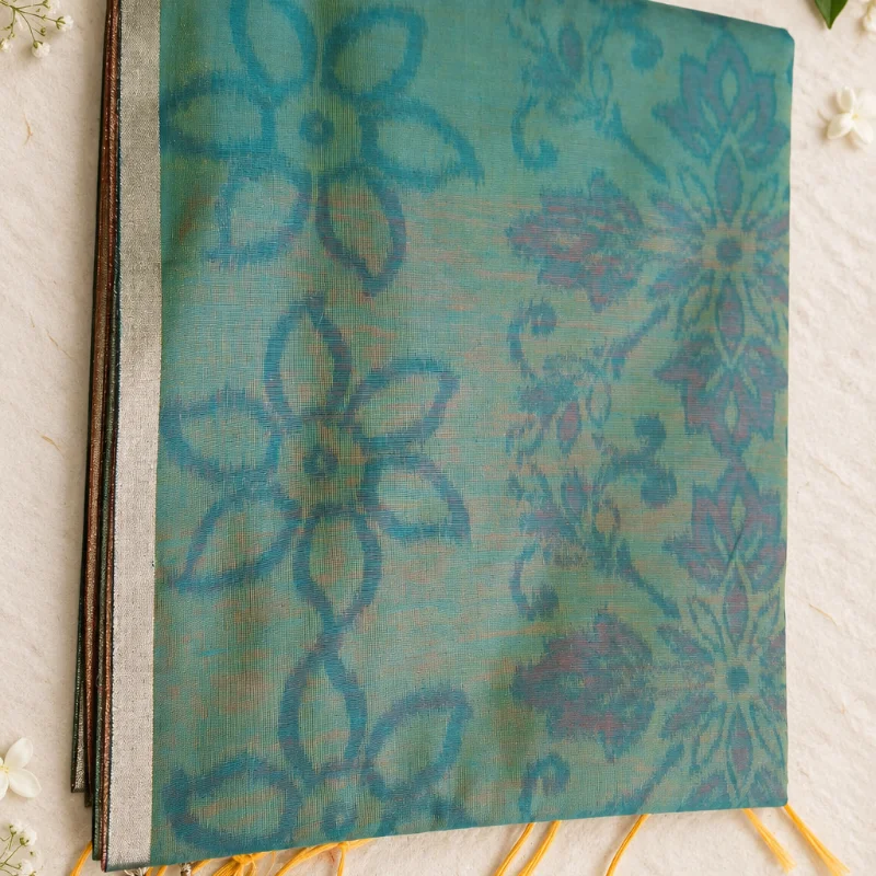 Elegant Teal Sea-Green Kalkatti Cotton Saree featuring bold, beautiful batik-style floral prints and a sleek metallic border